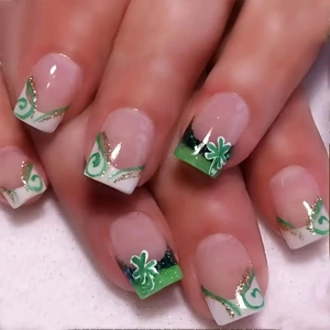 Détail de faux ongles French verts et blancs avec motifs de trèfles et de shamrocks