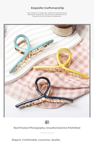 Detail view of large alloy hair claws in blue and yellow colors on a white tray