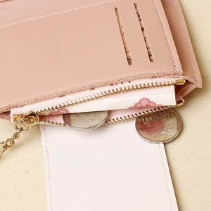 Dettaglio interno del portafoglio in pelle rosa con cerniera dorata e fessure per carte
