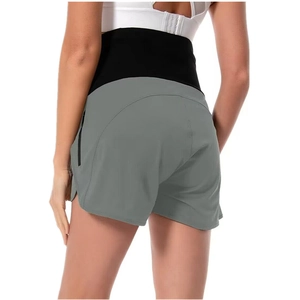 Dettaglio dell'ampia fascia nera di supporto premaman sui pantaloncini grigi