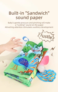 Detail of baby soft book with rustling sound paper and green peacock illustration