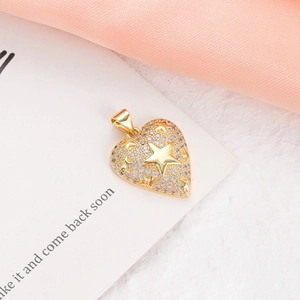 Macro detail of a gold heart charm with pavé stars and cubic zirconia on a card