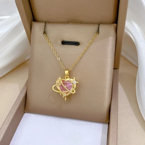 Detailed close-up of pink heart crystal necklace in planet design on silk fabric