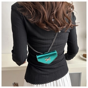 Détail du sac bandoulière vert émeraude avec papillon argenté et bandoulière chaîne