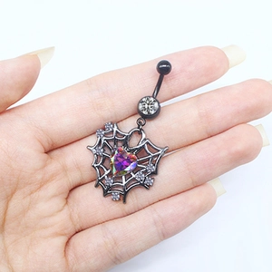 Detail of gothic spider web belly ring with rainbow heart stone held in hand