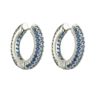 Macro view of silver hoop earrings with triple rows of pavé blue gemstones