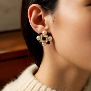 Close-up of model wearing 18k gold plated pearl flower stud earrings in vintage style