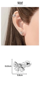 Detailed view of silver bow cartilage earring with dimensions and model ear placement
