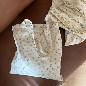 Detail of floral canvas tote bag stitching with minimalist white fabric label