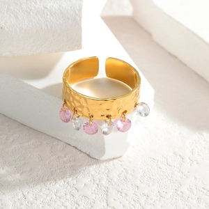 Macro view of gold hammered texture ring with pink and white faceted gemstone charms