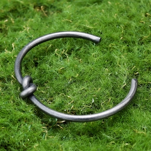 Macro detail of knot design on vintage stainless steel bangle with antique finish