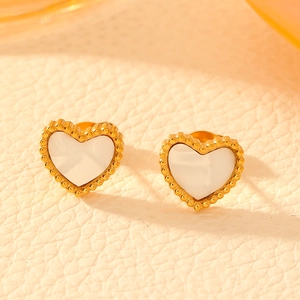 Macro shot of gold-plated heart stud earrings with white mother-of-pearl inlay