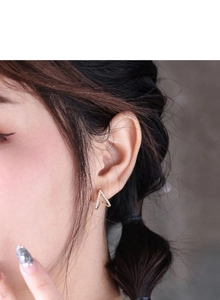 Close-up of elegant gold V-shaped silver stud earrings with sparkling cubic zirconia