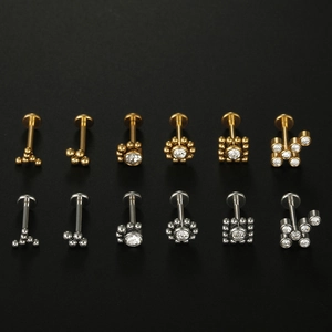 Detailed macro view of 316L stainless steel lip studs with cubic zirconia in gold and silver