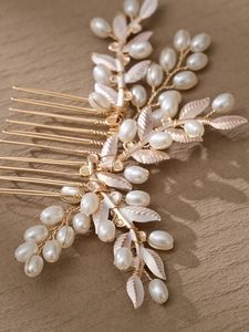 Detalle de peineta dorada con hojas y perlas para peinados de novia y ceremonias