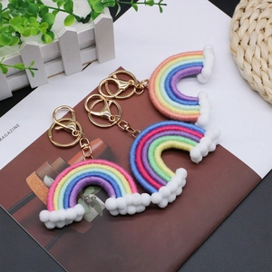 Handmade woven rainbow keychains in three colors with soft cloud poms and gold lobster clasp