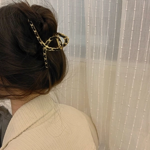 Elegant gold chain and black leather woven hair claw clip worn on hair back view