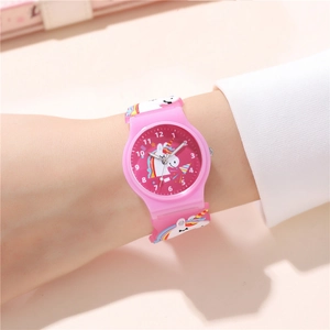 Detail of pink kids quartz watch showing cute unicorn pattern and soft silicone strap