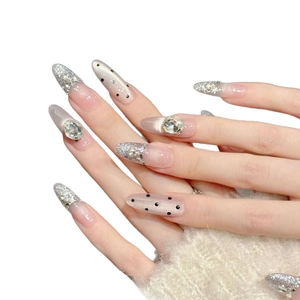 Handmade almond press-on nails in nude pink with glitter, rhinestones, and dots