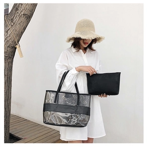 Detail of transparent PVC tote bag with black leather handles and inner pouch