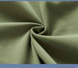 Gros plan du tissu polaire vert olive montrant la texture brossée et les fibres douces