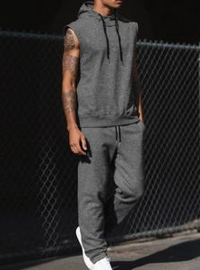 Outdoor street style view of men's sleeveless dark grey hoodie and jogger pants set