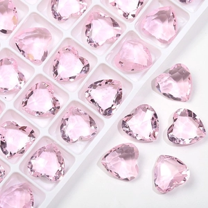 Vista macro di strass in vetro cristallo rosa 12mm a forma di cuore in un vassoio bianco