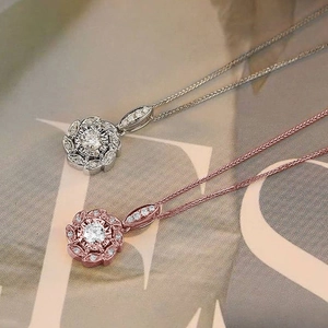 Gros plan de colliers à pendentif floral étincelant en argent et or rose avec zircons