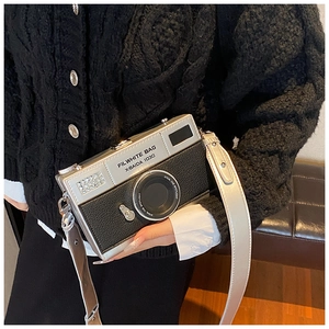 Detail of silver camera bag with wide strap and creative retro box shape design