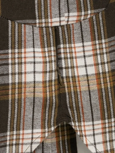 Gros plan de la fermeture éclair invisible sur une chemise à carreaux orange et marron