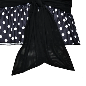 Detailed view of polka dot ruffles and black mesh bow on a slim fit party dress