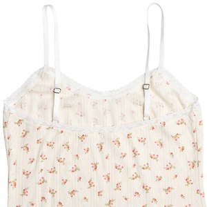 Detail of floral mini dress showing adjustable straps and delicate white lace trim