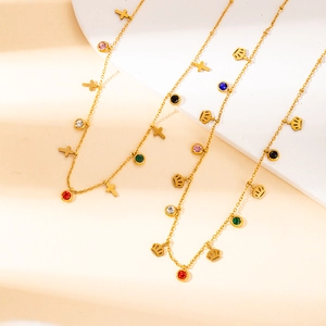 Elegant gold plated stainless steel necklaces with cross and crown pendants on beige fabric