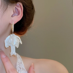 Detail of floral earring with pearl luster petals and gold crystal hoop on model