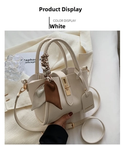 Détail du sac blanc crème avec poignée en foulard de soie et fermoir en métal doré