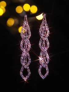 Close-up of luxury long tassel earrings with rose pink crystals and sparkling rhinestones