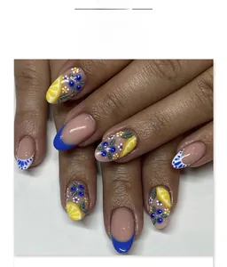 Detail of short round press-on nails featuring lemon, blueberry, and flower patterns
