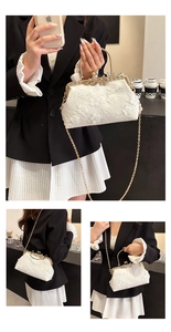 Detail of white lace embroidery evening bag with gold metal handle and chain strap