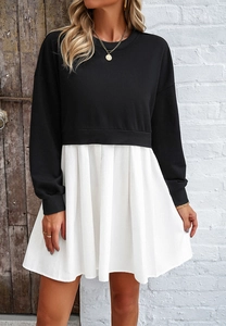 Détail de la robe patchwork noir et blanc avec jupe plissée et col rond élégant