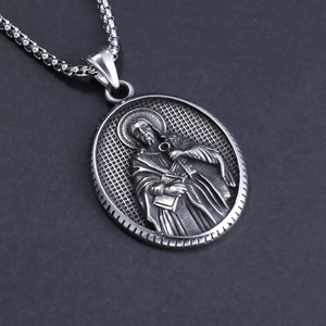 Silver oval pendant necklace featuring religious figure relief with woven chain link