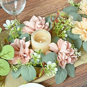 Artificial dahlia and eucalyptus wreath centerpieces with LED candle on dining table