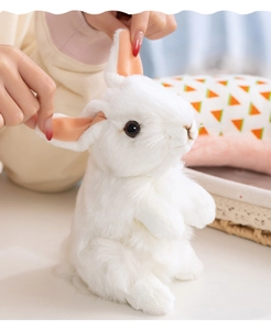 Close-up of soft white plush rabbit ear showing fluffy long-fiber faux fur and pink inner lining