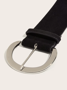 Gros plan d'une ceinture en daim noir avec boucle métallique argentée polie de qualité