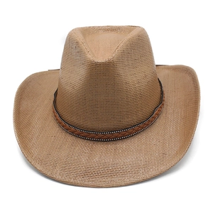 Close-up of brown straw cowboy hat featuring woven texture and studded leather band