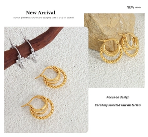 Detail of 18K gold and silver plated twist chain C-shape earrings on organic props