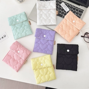 Detailed close-up of colorful quilted sanitary pads storage bags with heart patterns