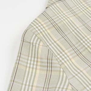 Detailed view of the plaid fabric shoulder seam on a green and beige tailored blazer