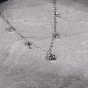 Elegant 925 sterling silver chain necklace featuring multiple lock, key, and zircon charms
