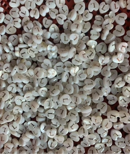 Macro detail of heart-shaped mother of pearl shell beads with gold letter L for DIY