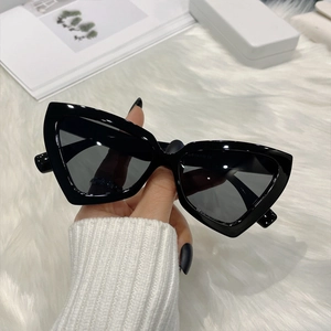Stylish black cat eye sunglasses for women with UV protection on white faux fur background